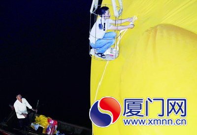 工人給大黃鴨系上繩子，準(zhǔn)備起吊