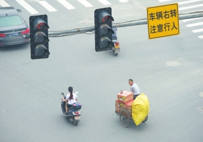 闖紅燈、不戴頭盔現(xiàn)象時有發(fā)生。本報記者陳明哲攝