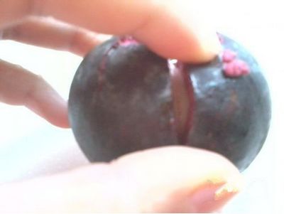 用菜刀，沿著其中兩瓣果肉的縫隙切下去
