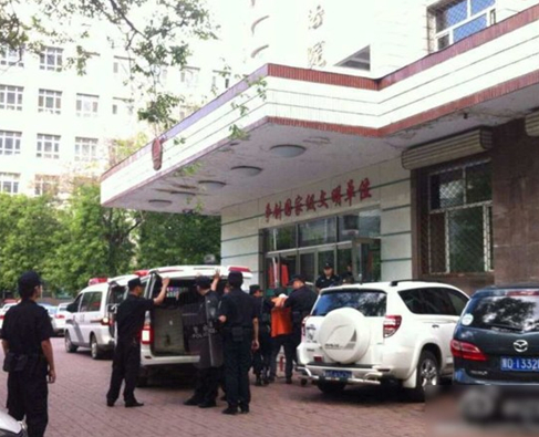兩名犯罪嫌疑人頭戴面罩，被法警押進(jìn)法庭。2