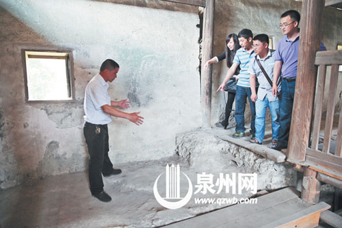 許進丁向游客們比劃著土樓墻體的厚度，當(dāng)年建造土樓