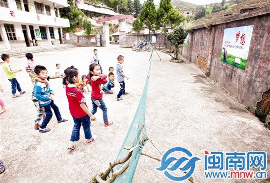 幾名小學生在操場上玩，學校的圍墻歪了一邊，用簡易