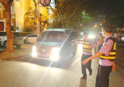 交警攔下濫開遠(yuǎn)光燈車輛。本報記者朱晨輝攝