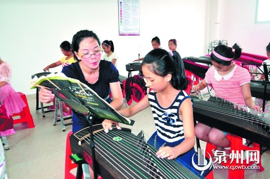 老師在指導(dǎo)學(xué)生彈奏古箏