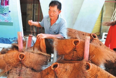 蓑衣制作傳承人詩(shī)山鎮(zhèn)鵬峰村的陳奕培在現(xiàn)場(chǎng)制作蓑衣。
