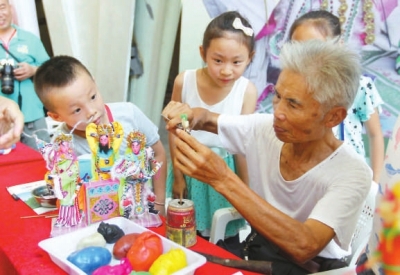 肖其昌在傳授小朋友妝糕人制作技藝。