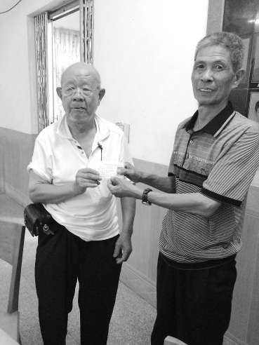 吳基揚（左）將辦好的證件遞交給村民。